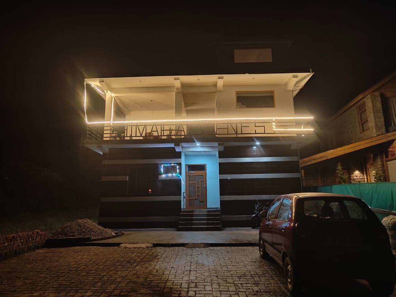 Himalayan Nest glowing at night with its illuminated balcony railing.